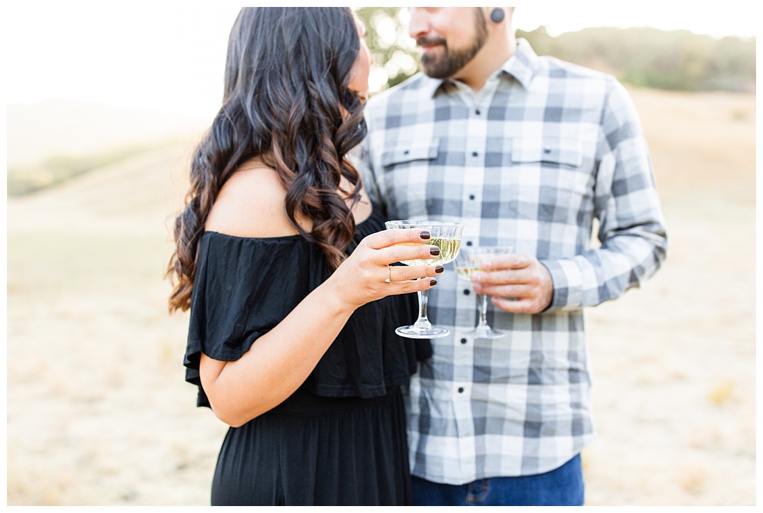 popping champagne bottle at engagement session