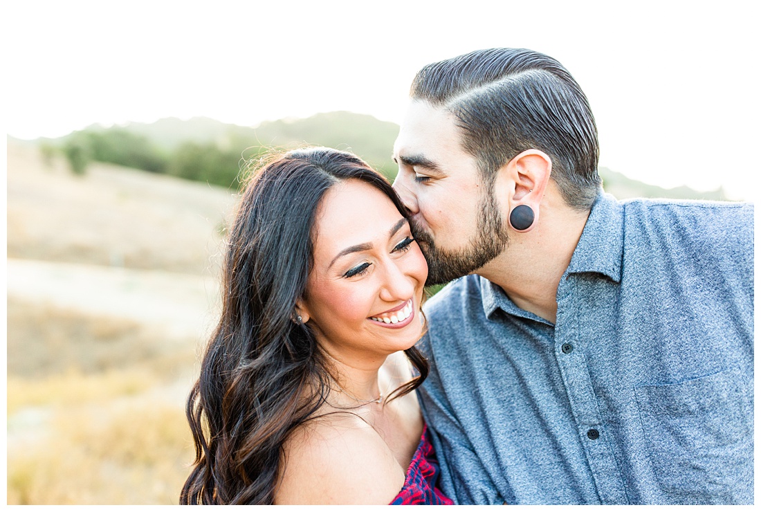 Guy kissing girl on cheek at engagement session