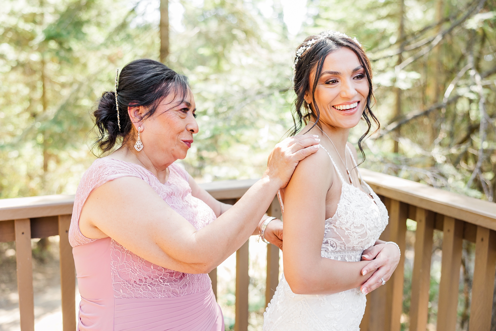 mother helping zip brides dress