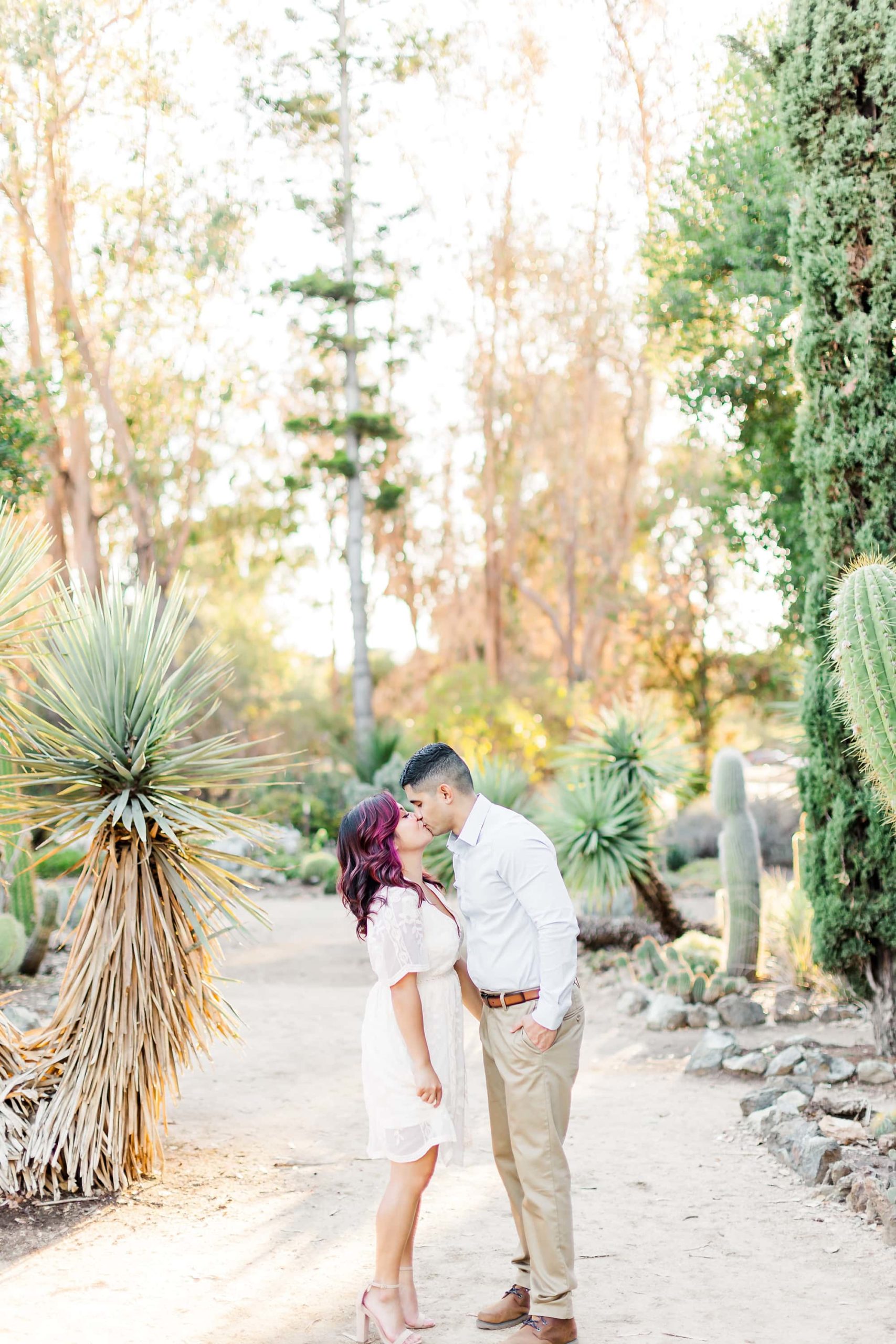 kissing pose at engagement session in stanford cactus garden