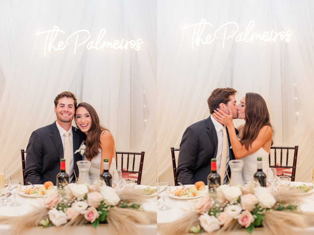 bride and groom at sweetheart table kissing