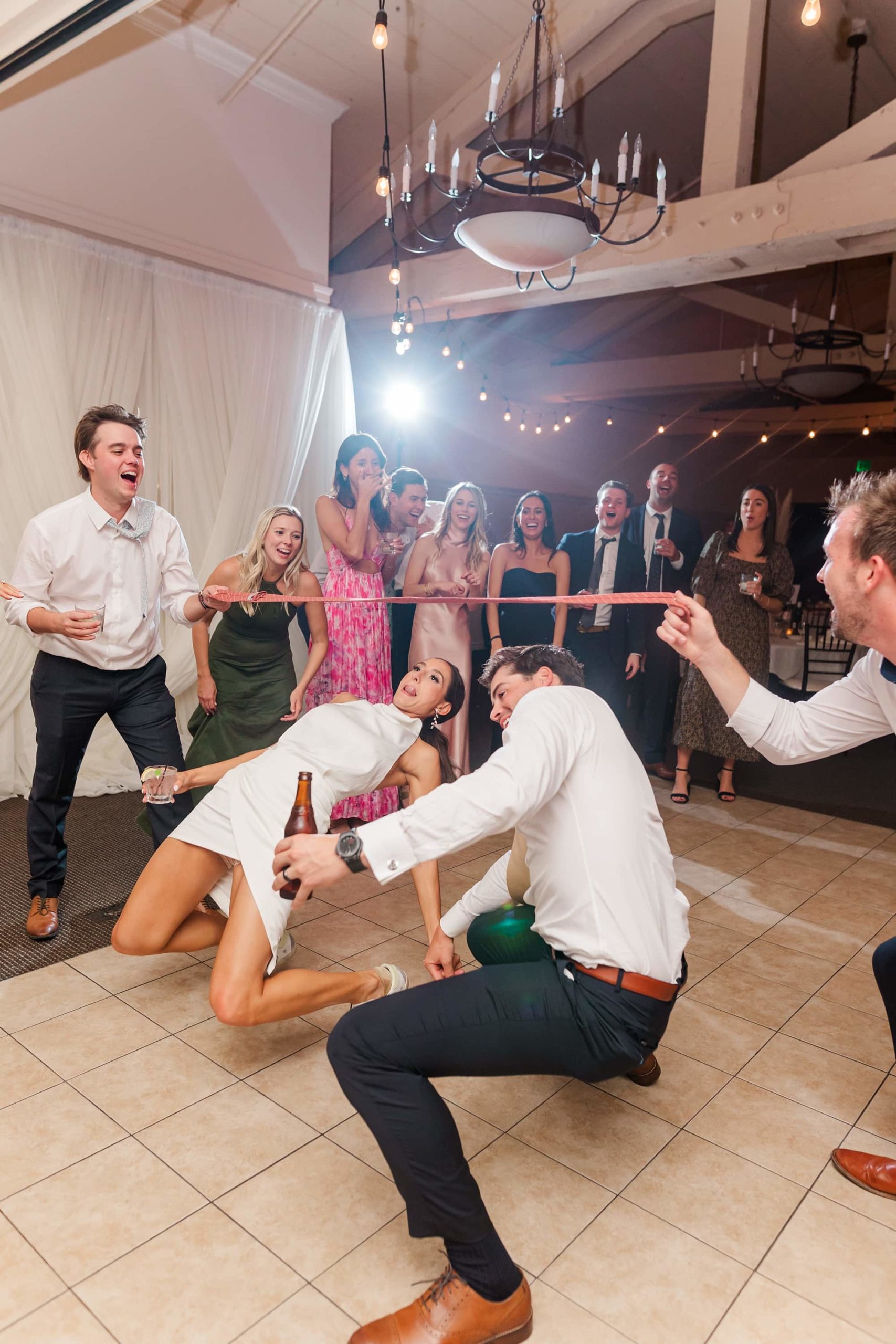 bride and groom doing the limbo at a wedding