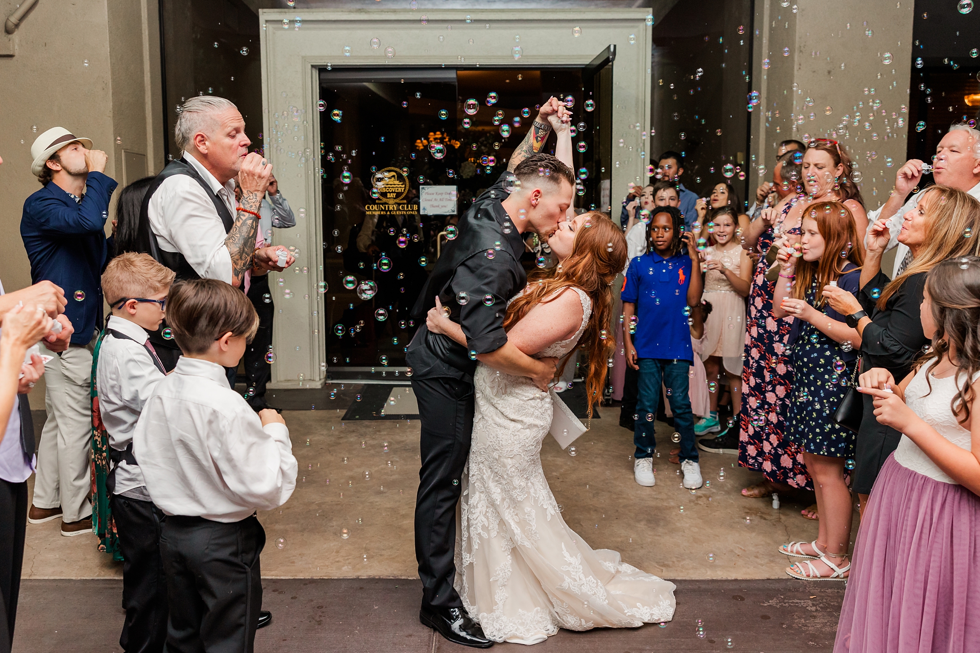 bride and groom kissing during bubble exit at wedding
