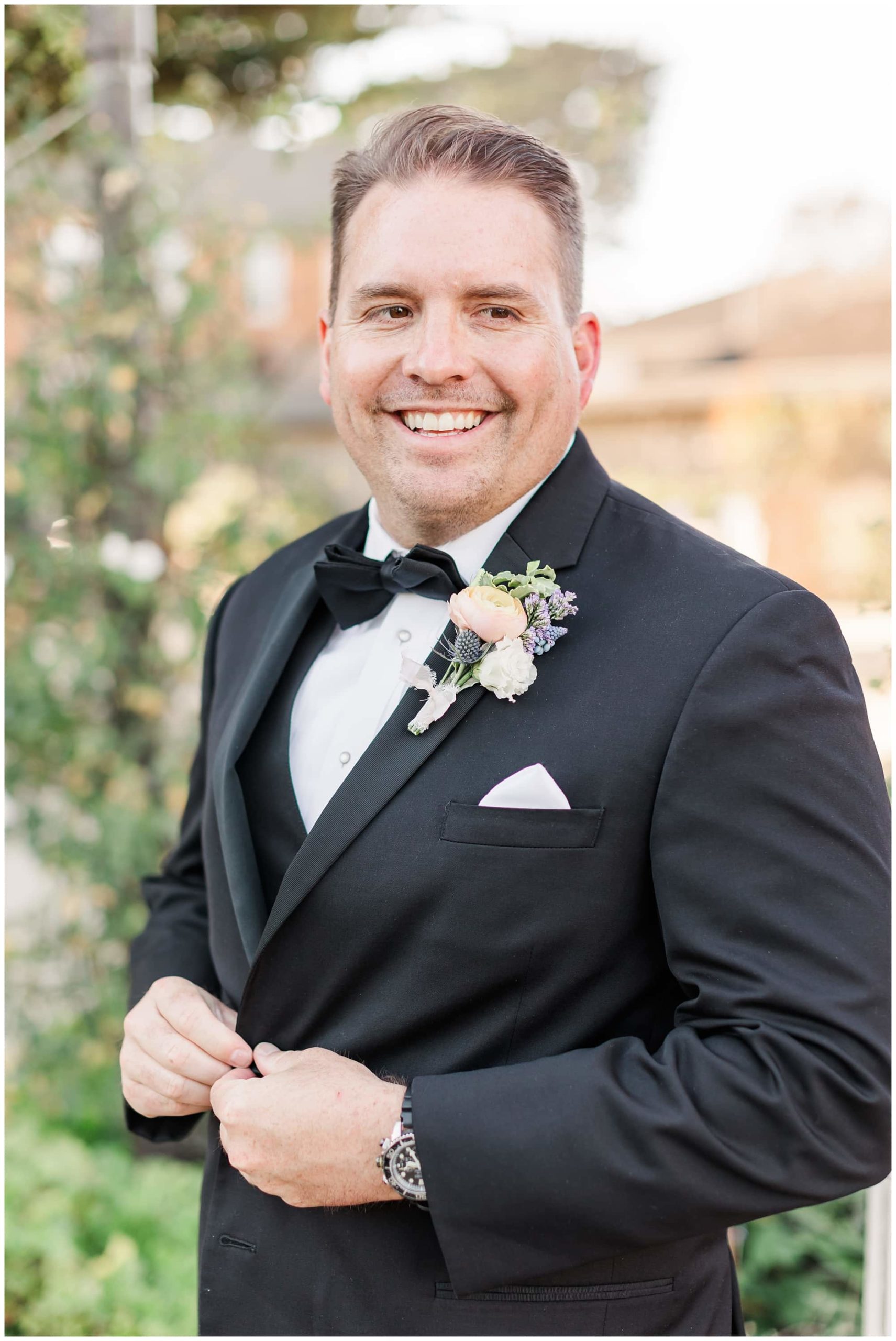 groom buttoning up jacket