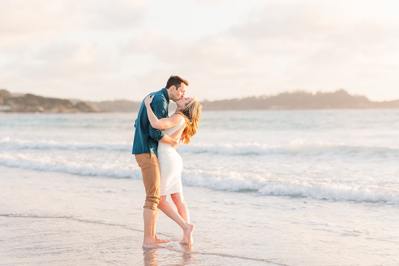 couple kissin at carmel beach with feet in water