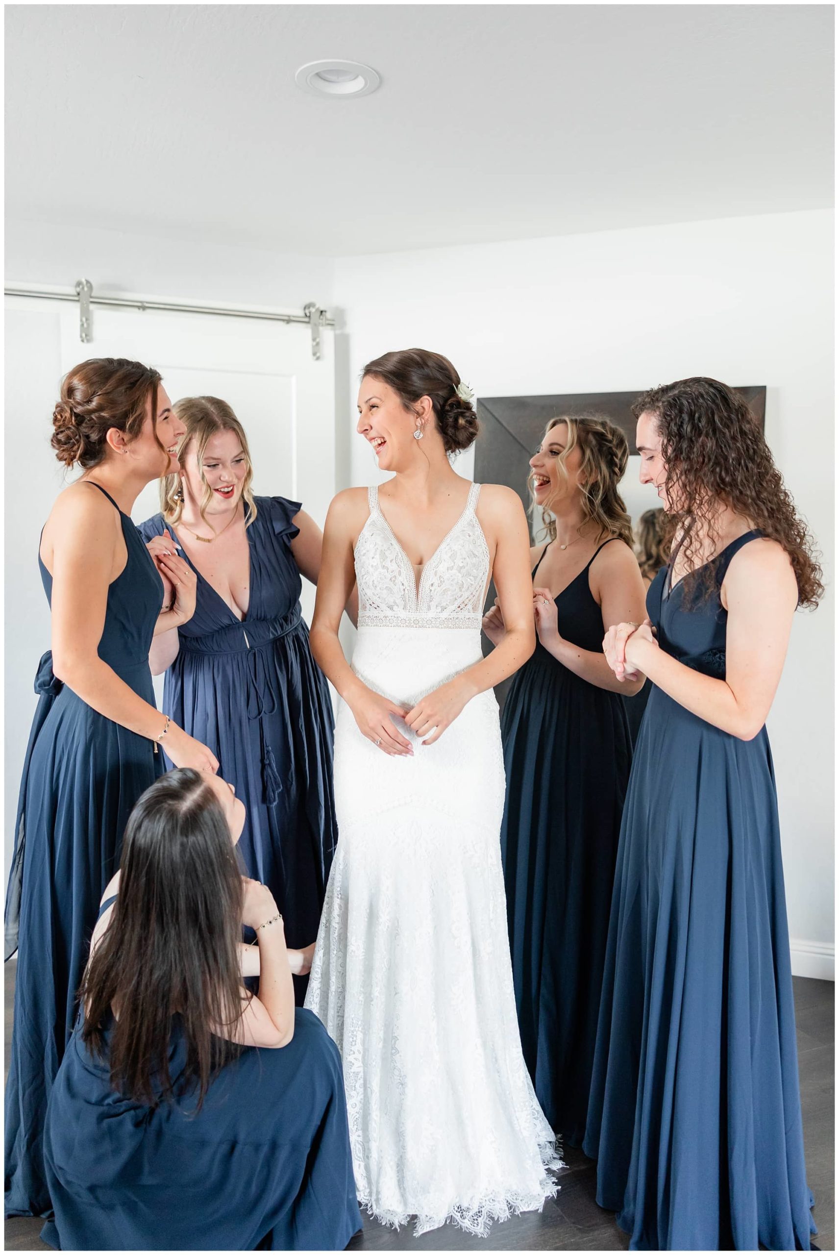 bridesmaids fluffing brides dress